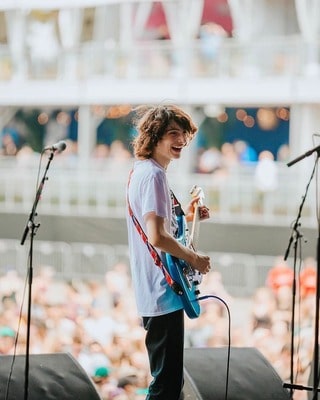 Canadian Actor Finn Wolfhard playing guitar during a live performance